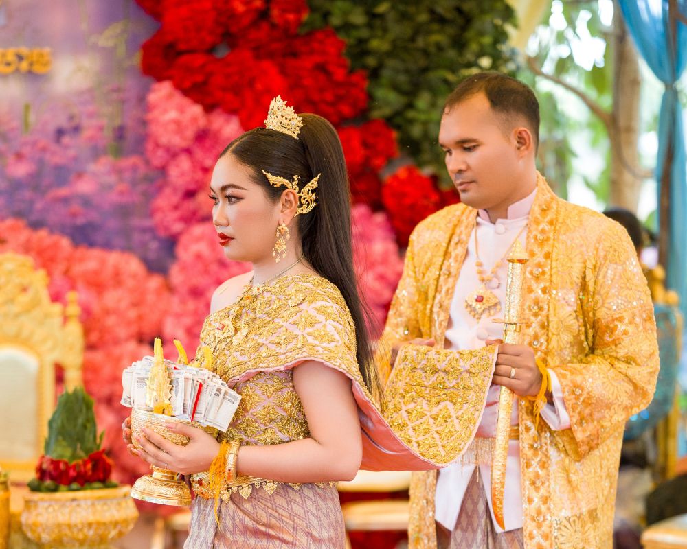 Cô dâu chú rể người Khmer trong nghi thức nhập phòng với cô dâu đi trước và chú rể nắm vạt áo theo sau