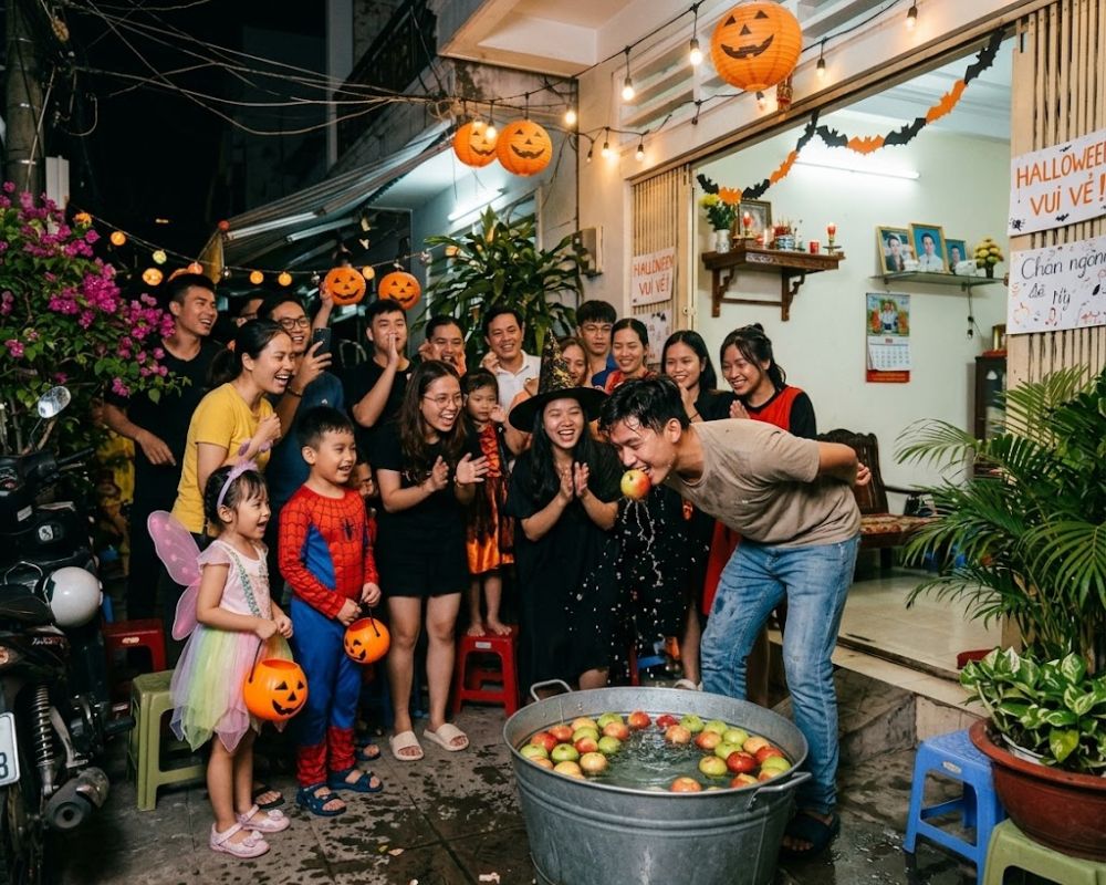 Mọi người hào hứng tham gia trò chơi đớp táo mang lại nhiều may mắn trong ngày Halloween